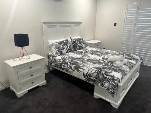 sypialnia z białym łóżkiem z pluszowym misiem w obiekcie Luxury home with huge pool and putting green! w mieście Townsville