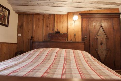 a bedroom with a bed with a striped blanket at ANNO 1698 Gîtes et Chambres d'Hôtes in Beblenheim
