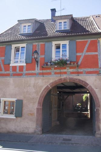 a building with an archway in front of it at ANNO 1698 Gîtes et Chambres d'Hôtes in Beblenheim