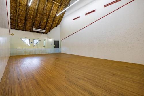 an empty room with a wooden floor and white walls at Sanbonani Hotel in Hazyview