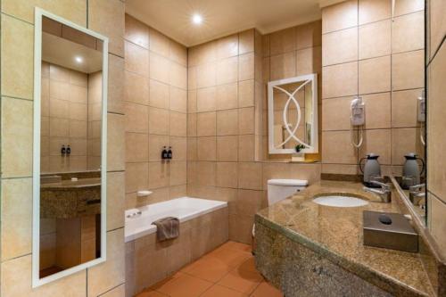 a large bathroom with a sink and a tub at Sanbonani Hotel in Hazyview
