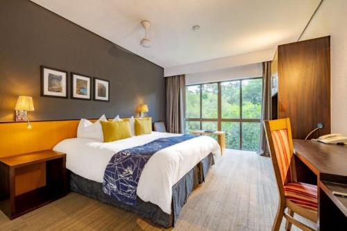 a hotel room with a bed and a desk at Sanbonani Hotel in Hazyview