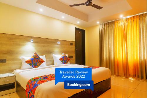 ein Hotelzimmer mit einem Bett mit einem Schild, auf dem die Reisebewertung steht in der Unterkunft FabHotel Surya Grand I in Vijayawāda