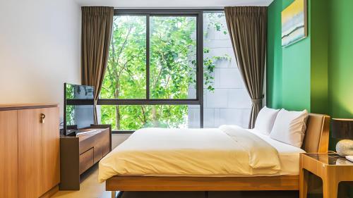 - une chambre avec un lit et une fenêtre dans l'établissement Hill & Valley Khaoyai by Nancy, à Ban Huai Sok Noi