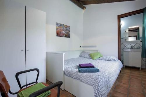 ein kleines Schlafzimmer mit einem Bett und einem Stuhl in der Unterkunft Casaventre in Vietri