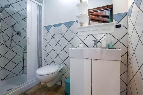 a white bathroom with a toilet and a sink at Casaventre in Vietri sul Mare