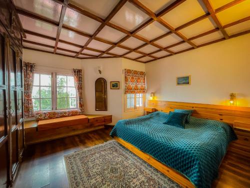 - une grande chambre avec un lit et une fenêtre dans l'établissement Birdwood Cottages, à Dalhousie