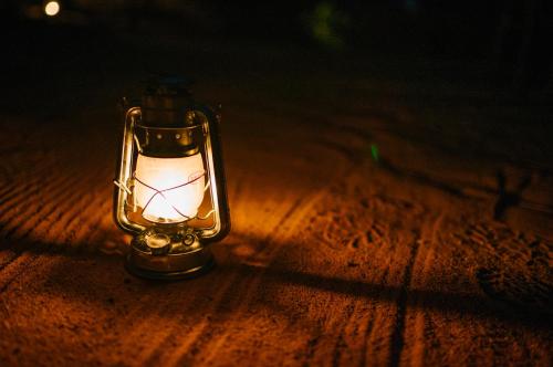 a small lantern sitting on top of a wooden table at Nedile Lodge in Welgevonden Game Reserve