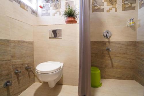 a bathroom with a toilet and a shower with a plant at Hotel The Omaira in Jaipur