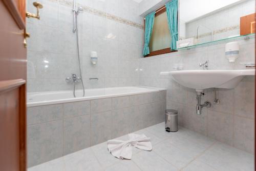 a bathroom with a sink and a tub and a sink at Apparthotel Thalerhof in Mayrhofen