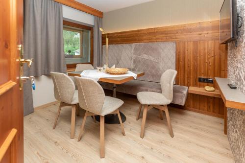 a dining room with a table and chairs at Apparthotel Thalerhof in Mayrhofen