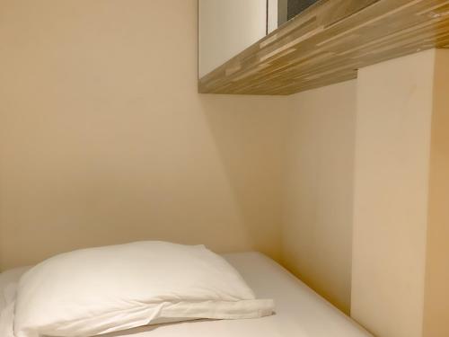 a white bed in a small room with a window at Omah Pelem Syariah in Semarang