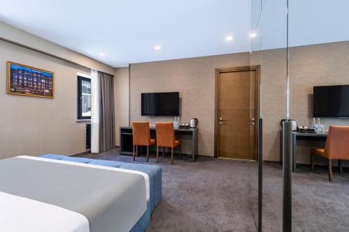 a hotel room with a bed and a table and chairs at Bristol Hotel and Spa Bakuriani in Bakuriani