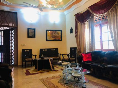 ein Wohnzimmer mit einem Sofa und einem Tisch in der Unterkunft Gulshan Family Couple Guest House Couple Hotel Gulshan-e-iqbal in Karatschi