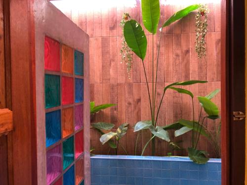 uma janela de vidro colorida numa casa de banho com uma planta em One World Bungalows em Ko Lanta