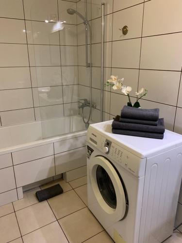 a washing machine in a bathroom with a tub at Near Station Apartment in Vilnius