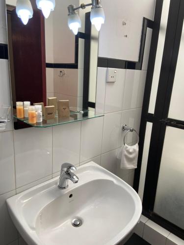 W łazience znajduje się umywalka i lustro. w obiekcie Kandy Garden Villa w mieście Kandy