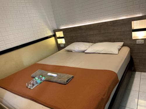 a bed with a bottle of water on it at Omah Pelem Syariah in Semarang