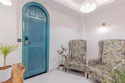 a room with two chairs and a blue door at Moustache Udaipur Luxuria in Udaipur