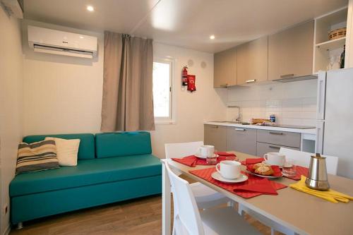 a kitchen with a table and a blue couch in a room at Camping Europa in Capoliveri