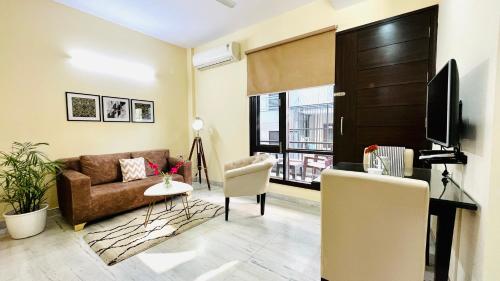 a living room with a couch and a tv at Olive Service Apartments - Artemis in Gurgaon