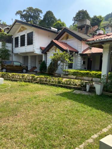 a house with a car parked in front of it at Kandy Garden Villa in Kandy