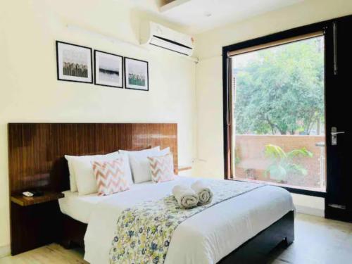 a bedroom with a bed with two towels on it at BluO 1BHK - DLF Golf Course Road , Balcony, Lift in Gurgaon