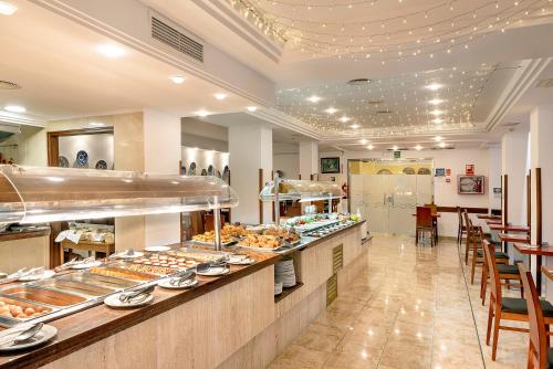 a bakery with a long counter with a lot of food at Hotel Biniamar in Cala Millor