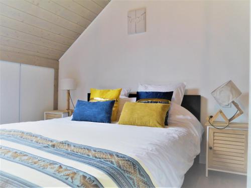 - une chambre avec un lit doté d'oreillers jaunes et bleus dans l'établissement 13K Arz, à Vannes