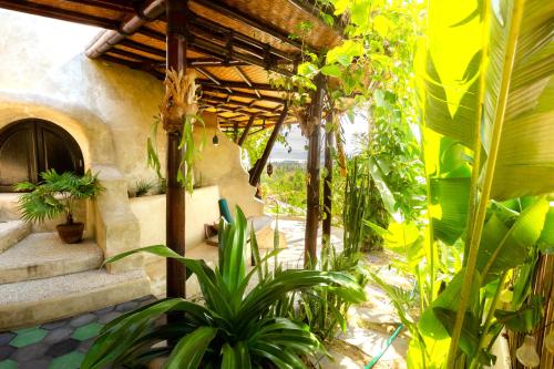 a garden with plants and a building with a staircase at Dome Lombok in Bumbang