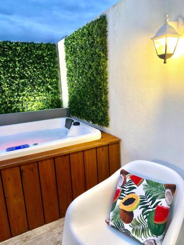 a bathroom with a tub and a chair with a pillow at Casa Tejo by Valada Village in Valada