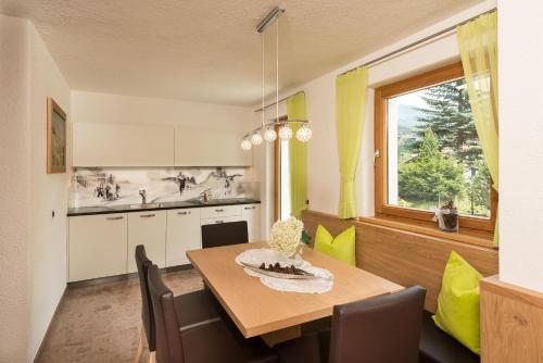 a kitchen with a dining room table and a window at Alpin Sport in Ortisei