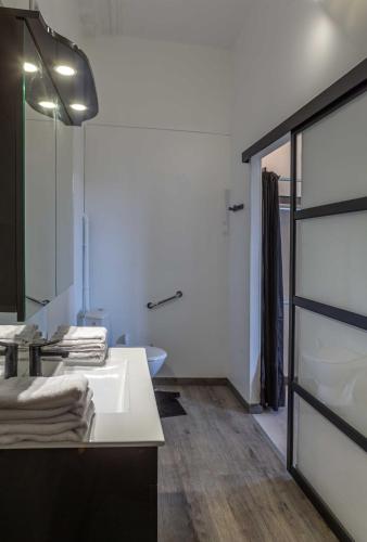 a bathroom with a white sink and a mirror at Chambre d'Hôtes Les Jardins de Marie, SCI Charles III in Bernay