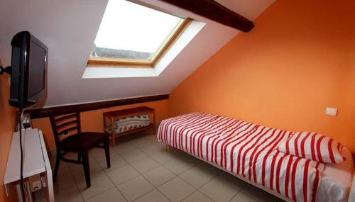 a bedroom with a bed and a tv and a window at Presqu'île de Chooz in Chooz