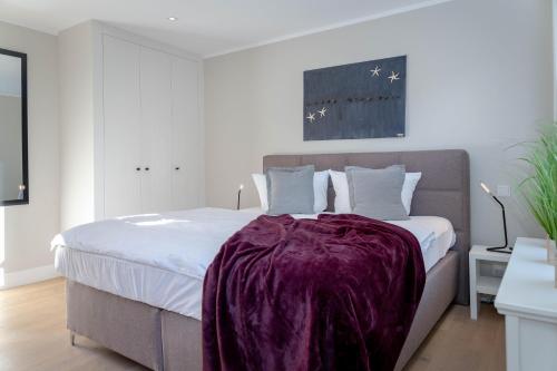 um quarto com uma cama com um cobertor roxo em Stadtperle Silver em Westerland