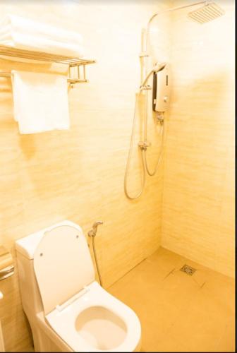 a small bathroom with a toilet and a shower at THE CROWN HOTEL @ KLIA in Sepang