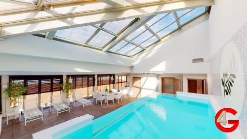 a swimming pool in a building with a glass ceiling at THE POOL HOUSE Cannes in Cannes