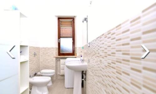 baño con 2 aseos y lavamanos en Appartamento al Centro di Valenza en Valenza