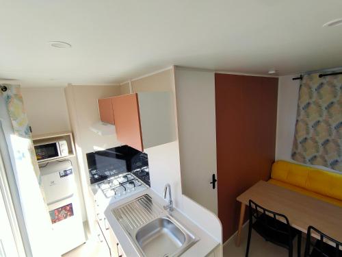 a small kitchen with a sink and a table at Camping Valencia el Saler in El Saler