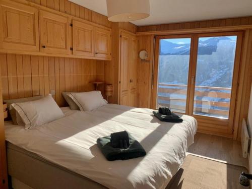 a bedroom with a large bed with two hats on it at Antika 216 in Verbier