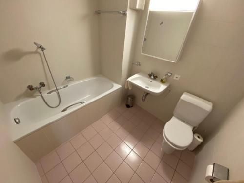 ein Badezimmer mit einer Badewanne, einem WC und einem Waschbecken in der Unterkunft Antika 216 in Verbier