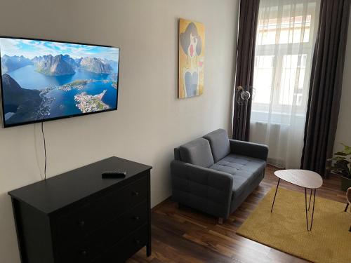 een woonkamer met een bank en een tv aan de muur bij Gesamte Unterkunft in Zentrumsnähe in Wenen