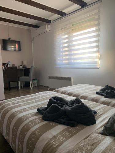 dwa łóżka z ręcznikami na nich w sypialni w obiekcie Alex Lodge w mieście Zrenjanin