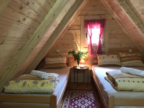 two beds in a attic room with a window at Rafting centar RT in Foča
