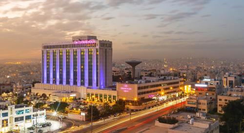 un edificio iluminado en una ciudad por la noche en Crowne Plaza Amman, an IHG Hotel, en Amán