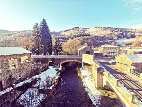 a bridge over a river with snow on the ground at Auberge de Chanteuges in Chanteuges