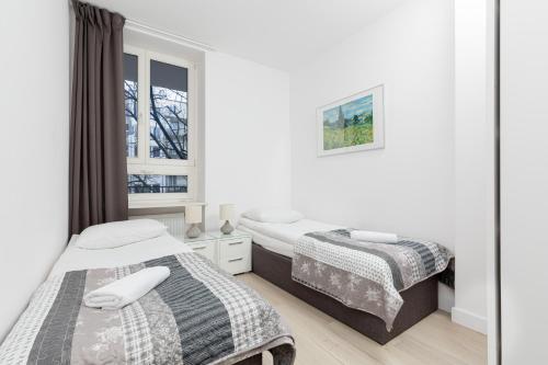 1 dormitorio con 2 camas y ventana en City Center Apartments Hoża by Renters, en Varsovia