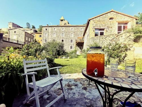 a patio with a table and a chair and a jar of honey at Auberge de Chanteuges in Chanteuges