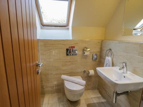 a bathroom with a toilet and a sink at Clematis Cottage in Whitby