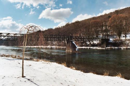 a bridge over a river with snow on the ground at Gîte des trois vallees in Nouzonville